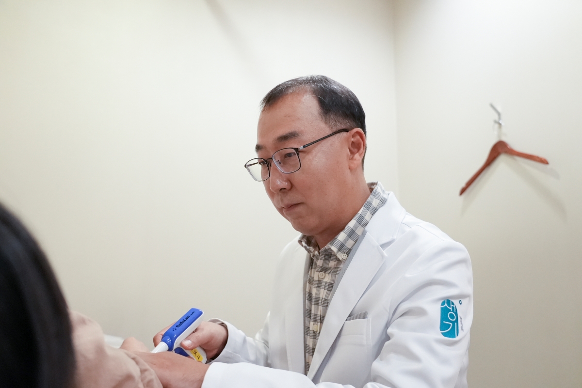 치료실에서 손 피부 병변에 맞춰 치료를 진행합니다.