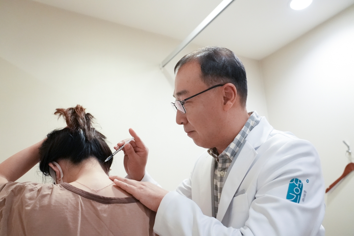 목과 두피 경계 부위의 피부 상태를 살피며 치료합니다.